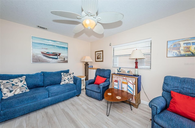 living room featuring a textured ceiling, wood finished floors, and visible vents