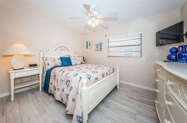 bedroom with light wood finished floors, baseboards, and a ceiling fan