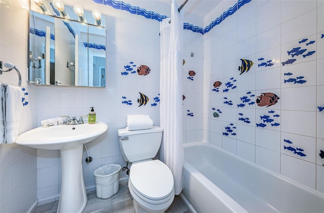 full bathroom featuring toilet, a sink, tile walls, decorative backsplash, and shower / tub combo with curtain