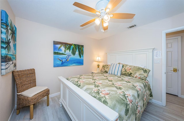 bedroom featuring a ceiling fan, baseboards, visible vents, and light wood finished floors