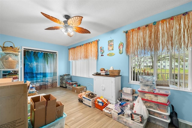 interior space featuring a textured ceiling, a ceiling fan, and wood finished floors