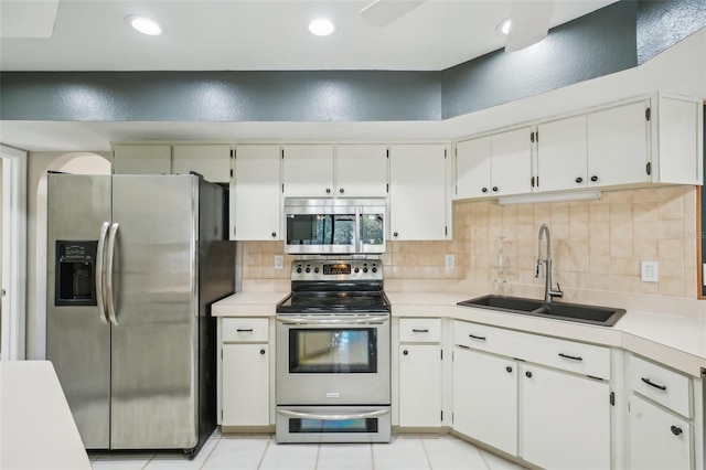 kitchen featuring decorative backsplash, appliances with stainless steel finishes, light countertops, and a sink