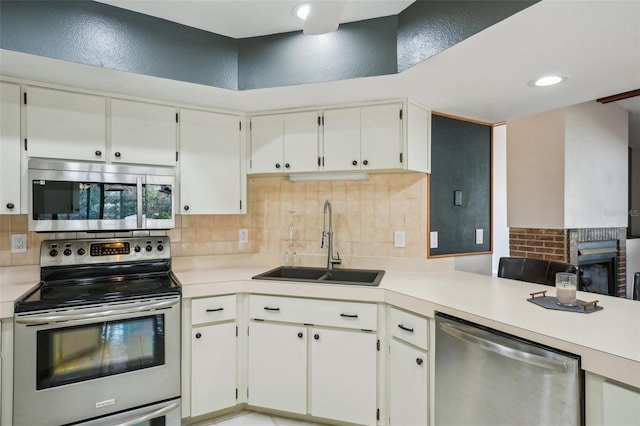 kitchen with decorative backsplash, appliances with stainless steel finishes, light countertops, and a sink