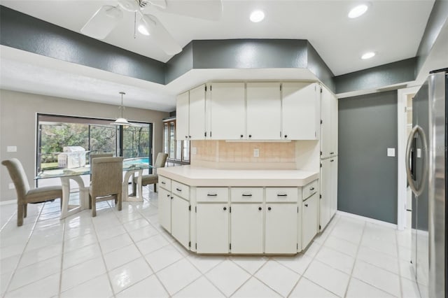 kitchen with freestanding refrigerator, ceiling fan, decorative backsplash, light countertops, and white cabinetry