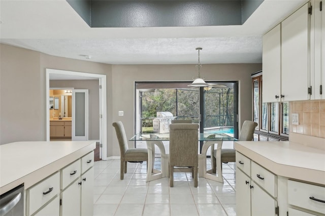 dining room with light tile patterned floors, baseboards, and a textured ceiling