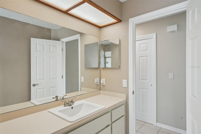 bathroom with tile patterned flooring, vanity, and baseboards