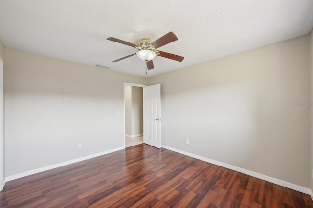 spare room with ceiling fan, visible vents, baseboards, and wood finished floors