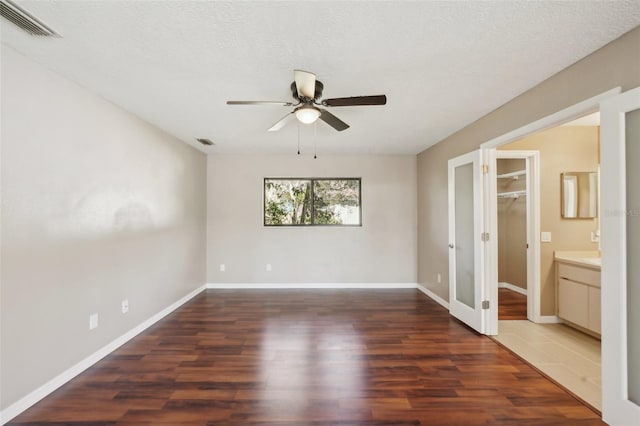 unfurnished bedroom featuring visible vents, baseboards, and wood finished floors