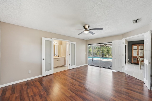 interior space featuring wood finished floors, baseboards, visible vents, ceiling fan, and french doors