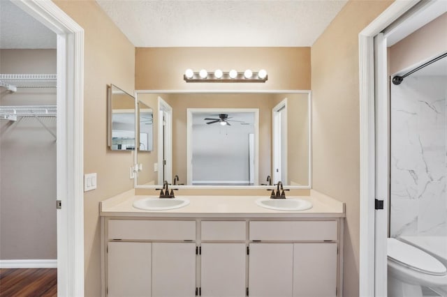 full bathroom featuring a sink, toilet, ceiling fan, and double vanity