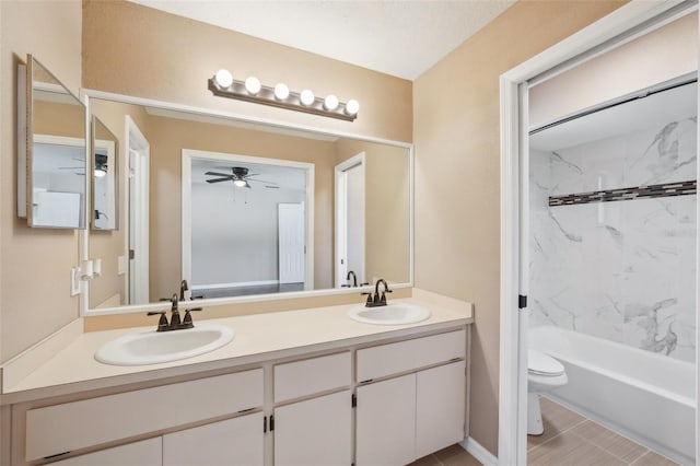 full bath featuring double vanity, toilet, ceiling fan, and a sink