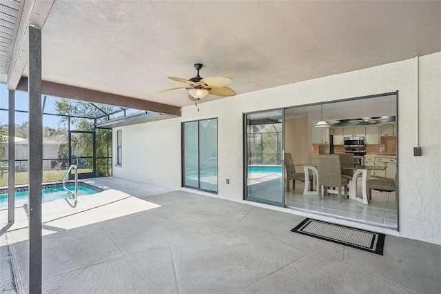 pool with a lanai, a patio area, and ceiling fan