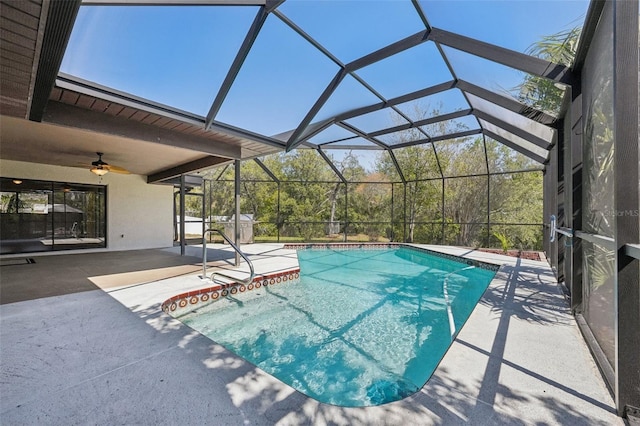 outdoor pool with glass enclosure, a patio area, and ceiling fan