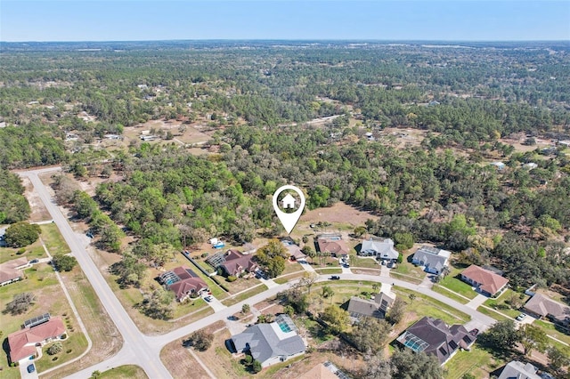 drone / aerial view featuring a residential view and a view of trees