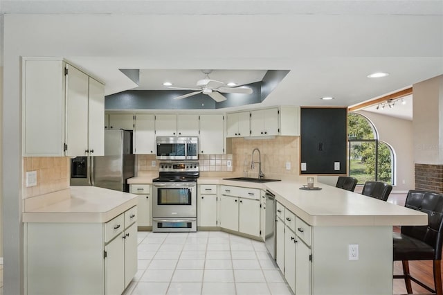 14048 Bruni Dr, Spring Hill, FL 34609 - kitchen with stainless steel appliances, a peninsula, light countertops, ceiling fan, and decorative backsplash