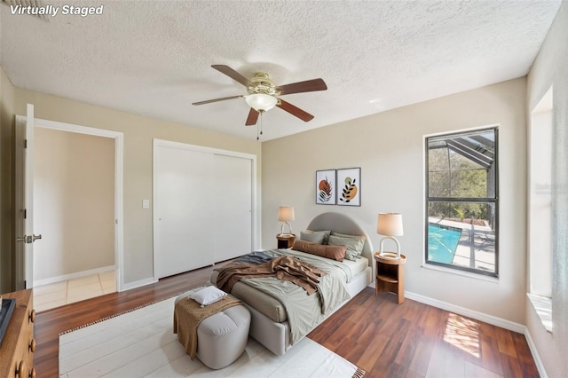 14048 Bruni Dr, Spring Hill, FL 34609 - bedroom with wood finished floors, a textured ceiling, a closet, and a ceiling fan