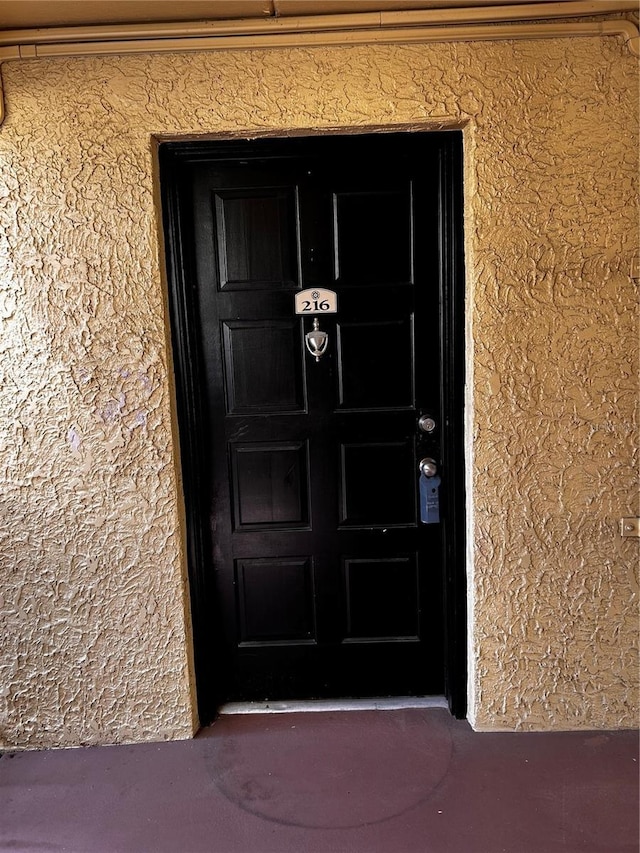 entrance to property featuring stucco siding