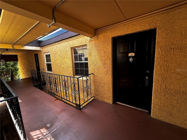 doorway to property with stucco siding and a balcony