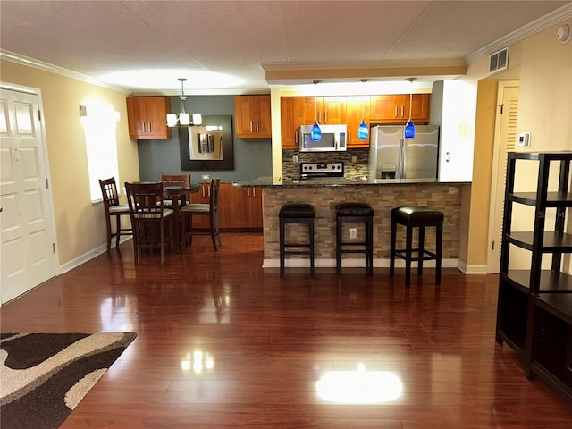 kitchen with a breakfast bar, crown molding, decorative backsplash, and stainless steel appliances