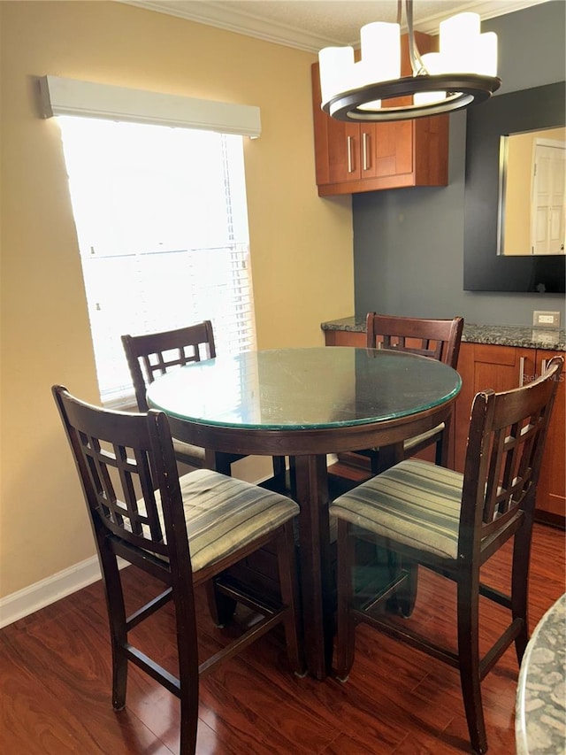 dining space featuring baseboards, dark wood-style flooring, and crown molding