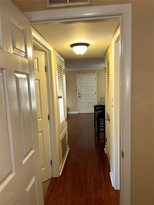 hall featuring visible vents and dark wood-style floors