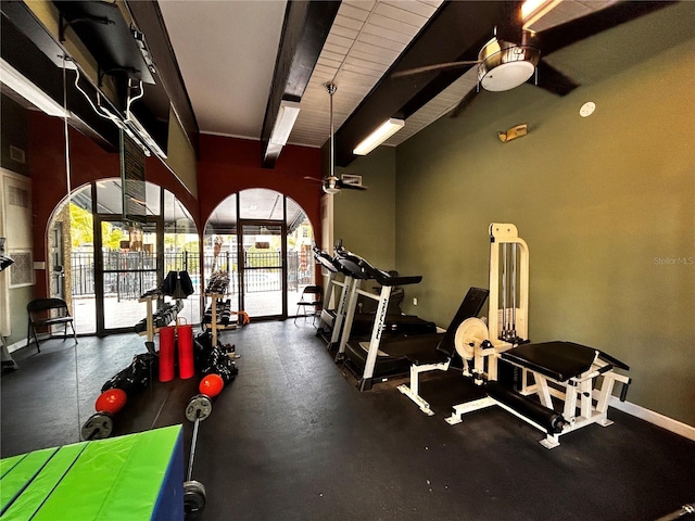 gym with a ceiling fan and baseboards