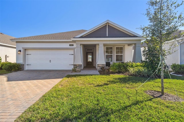 view of front of house with decorative driveway, a front lawn, an attached garage, and stucco siding