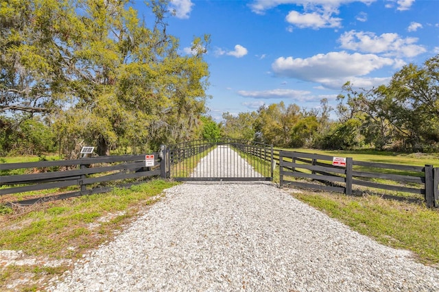 view of gate featuring a rural view and fence