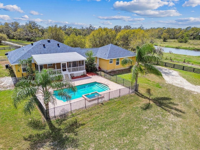 view of pool featuring a pool with connected hot tub, a yard, a fenced backyard, and a sunroom