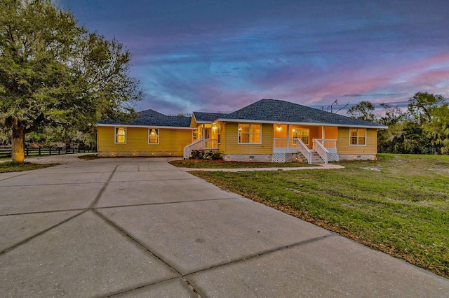 ranch-style house featuring fence, a shingled roof, concrete driveway, crawl space, and a lawn