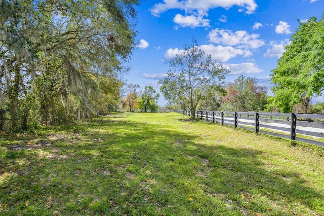 view of yard featuring a rural view and fence