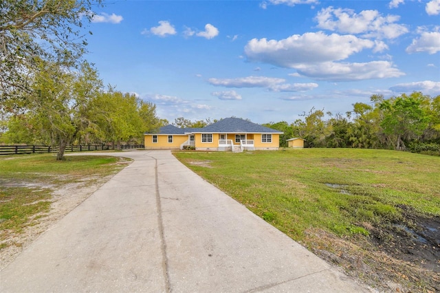 ranch-style home with concrete driveway, a front yard, and fence