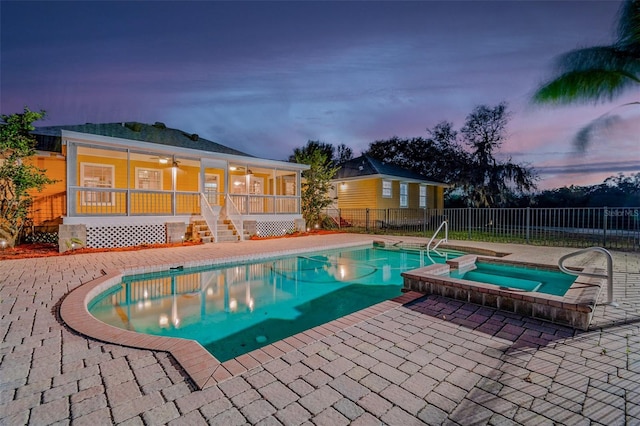 view of swimming pool featuring a patio area, fence, a pool with connected hot tub, and ceiling fan