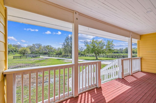 wooden deck with a rural view and fence