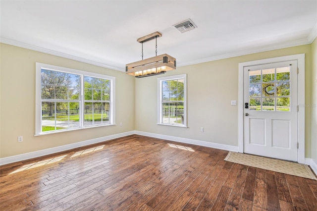 unfurnished dining area with visible vents, plenty of natural light, ornamental molding, and dark wood finished floors