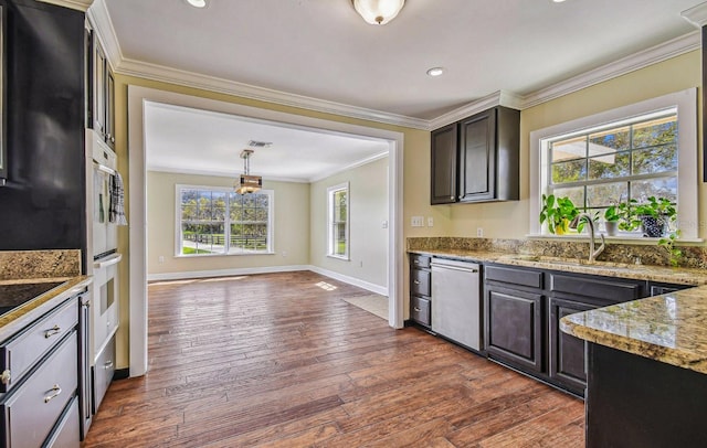 kitchen with light stone counters, dark wood-style flooring, a sink, dishwasher, and crown molding