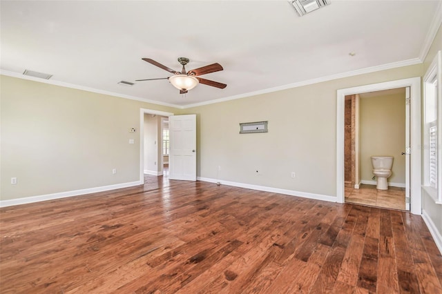 spare room featuring visible vents, baseboards, wood finished floors, and ornamental molding