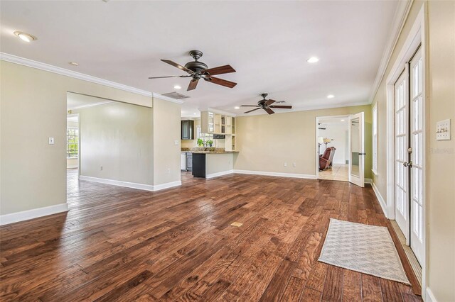 unfurnished living room featuring ornamental molding, baseboards, and dark wood-style flooring