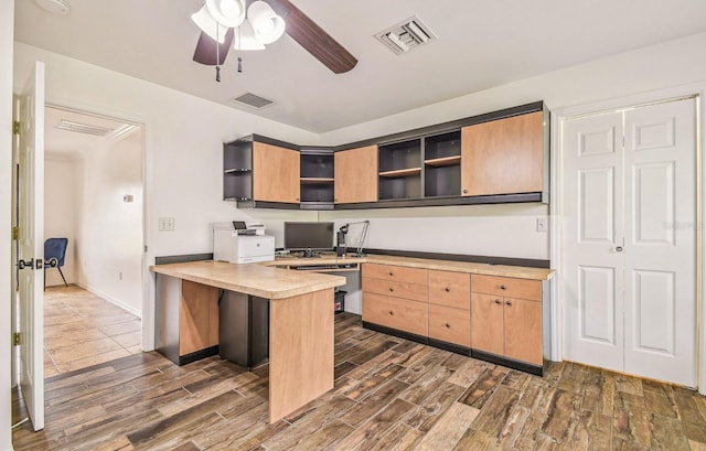 kitchen with open shelves, a peninsula, visible vents, and wood finish floors