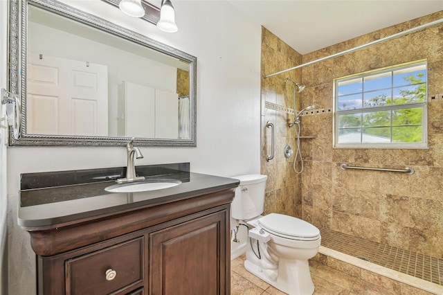 bathroom featuring vanity, toilet, and a tile shower