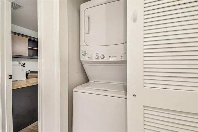 laundry room with laundry area, stacked washing maching and dryer, and visible vents