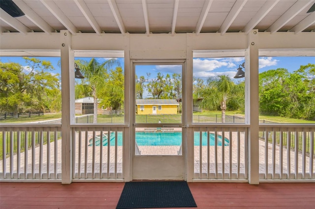 unfurnished sunroom featuring beamed ceiling