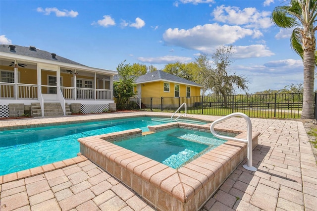 view of pool with a patio, fence, a pool with connected hot tub, a sunroom, and ceiling fan