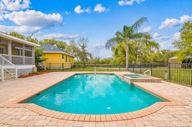 view of swimming pool featuring a patio area, a pool with connected hot tub, a sunroom, and fence