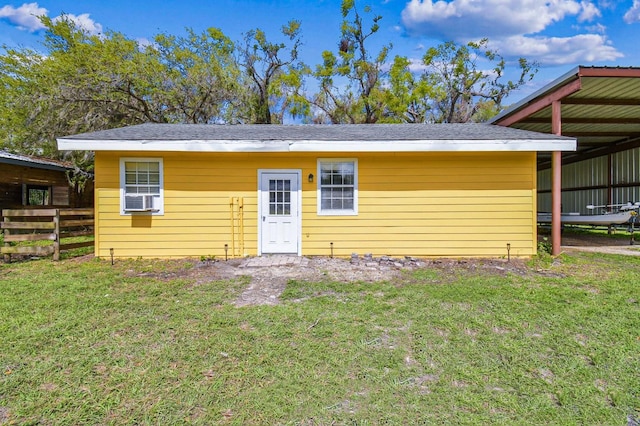 rear view of property with cooling unit, a lawn, and fence