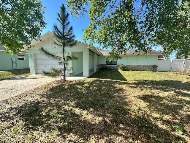 exterior space with a garage, concrete driveway, a gate, fence, and a yard