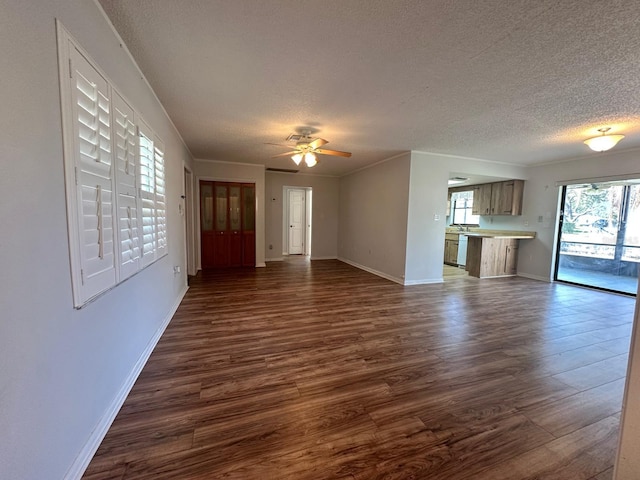 unfurnished living room featuring dark wood-style floors, a textured ceiling, baseboards, and a ceiling fan