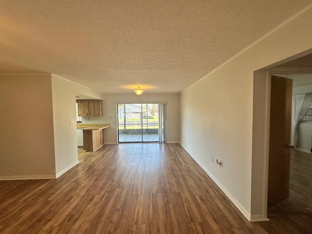 unfurnished living room with crown molding, a textured ceiling, baseboards, and dark wood-type flooring