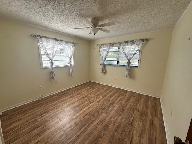 empty room featuring a ceiling fan, a textured ceiling, baseboards, and wood finished floors