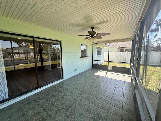 unfurnished sunroom featuring ceiling fan